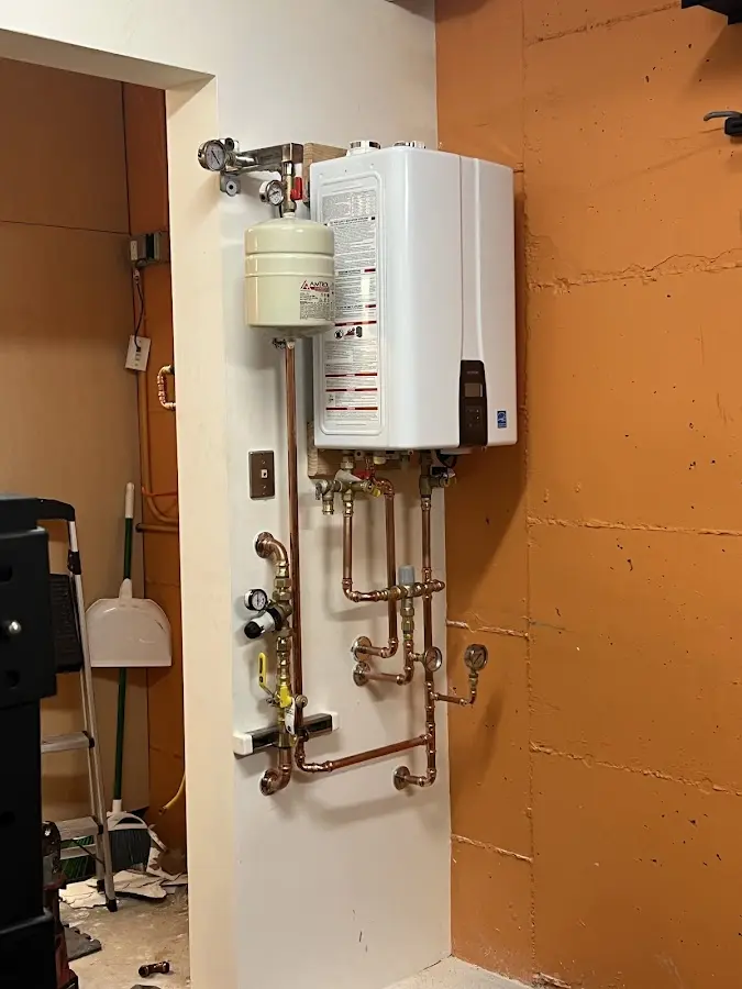 Plumbing technician inspecting water heater connections in Rio del Mar